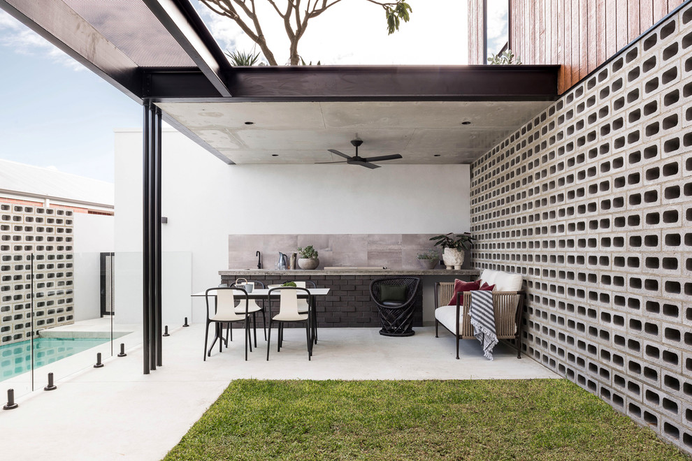 Свежая идея для дизайна: двор на заднем дворе в современном стиле с летней кухней, покрытием из бетонных плит и козырьком - отличное фото интерьера