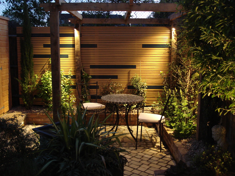 На фото: маленький двор на заднем дворе в стиле фьюжн с покрытием из каменной брусчатки для на участке и в саду с
