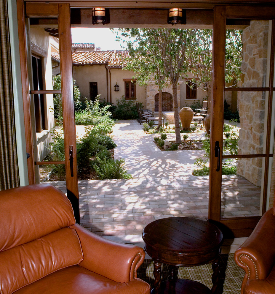 Foto de patio mediterráneo de tamaño medio sin cubierta en patio trasero con brasero y adoquines de ladrillo