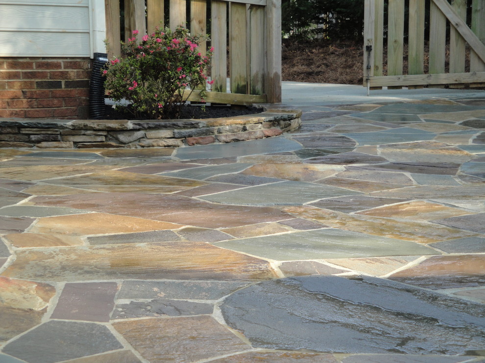 Mid-sized mountain style backyard stone patio kitchen photo in Raleigh with no cover