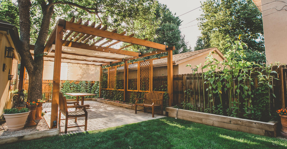 Ejemplo de patio clásico grande en patio trasero con jardín vertical, adoquines de hormigón y pérgola