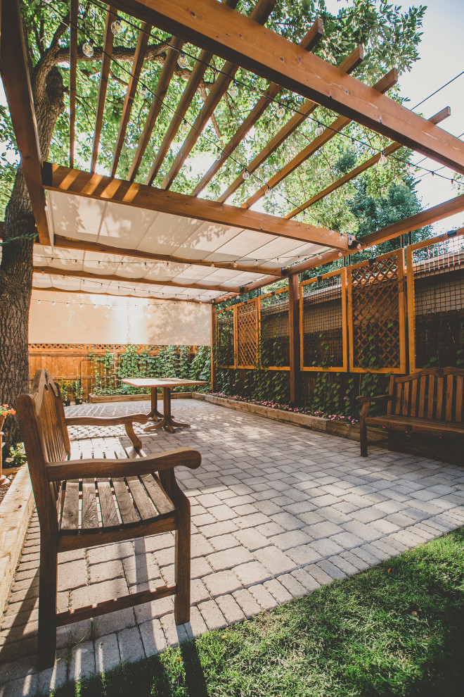 Foto de patio tradicional grande en patio trasero con jardín vertical, adoquines de hormigón y pérgola