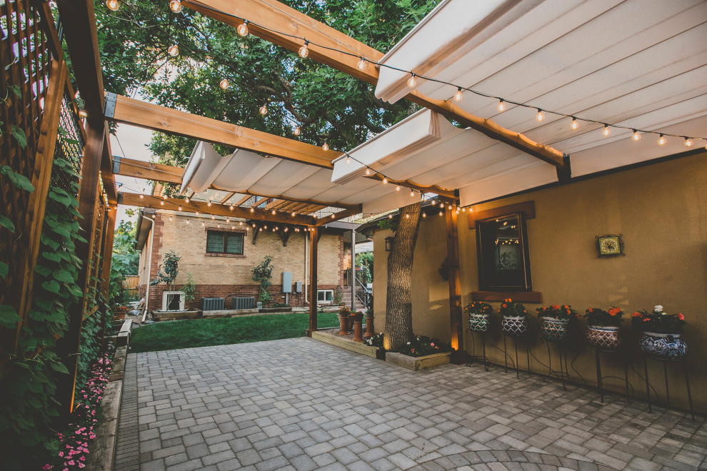 Diseño de patio clásico grande en patio trasero con jardín vertical, adoquines de hormigón y pérgola