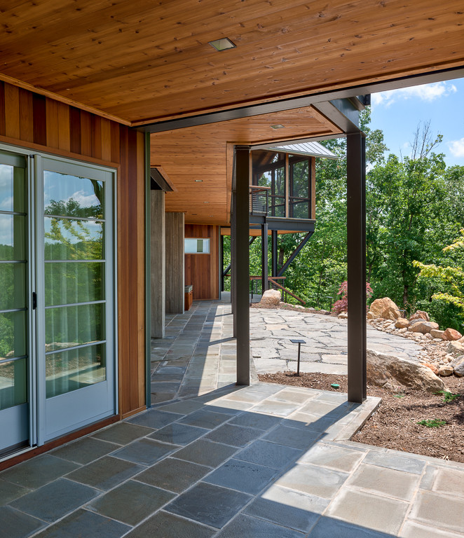 Imagen de patio contemporáneo de tamaño medio en patio trasero y anexo de casas con ducha exterior y adoquines de piedra natural