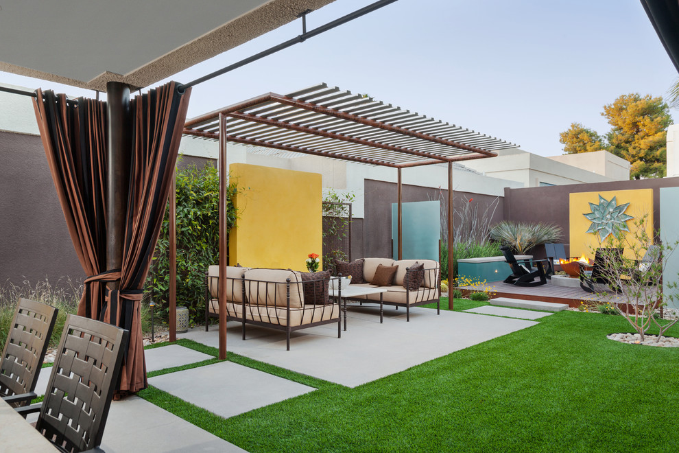 Idée de décoration pour une grande terrasse arrière minimaliste avec un foyer extérieur et une extension de toiture.