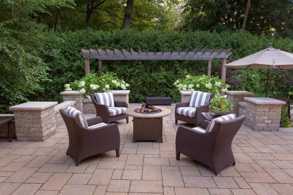 Patio - traditional backyard stone patio idea in Toronto with a fire pit and no cover