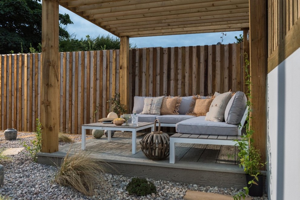 Inspiration for a small tropical backyard patio remodel in Cornwall with decking and a pergola