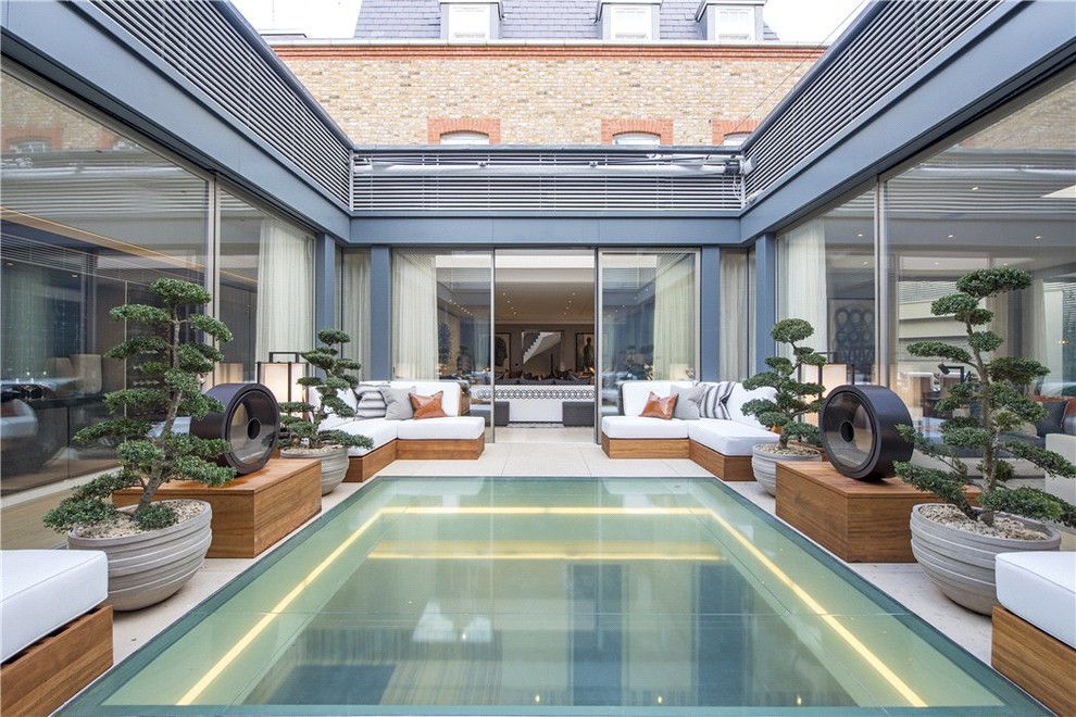 Large contemporary side patio in London with natural stone paving.