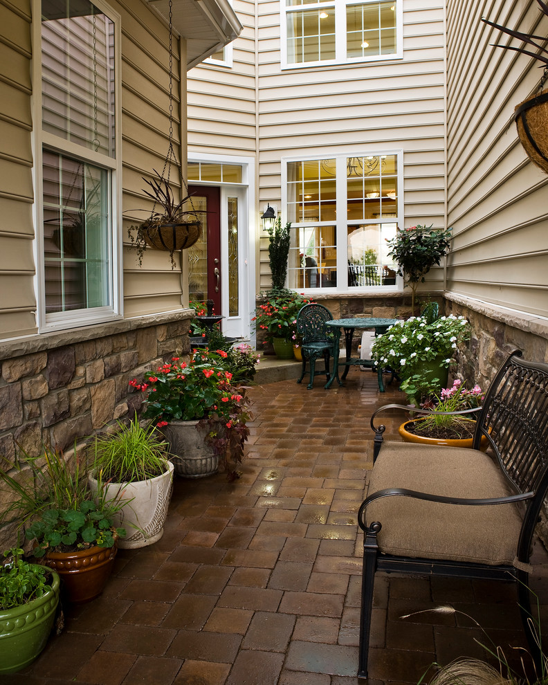 Esempio di un patio o portico tradizionale davanti casa con un giardino in vaso e nessuna copertura