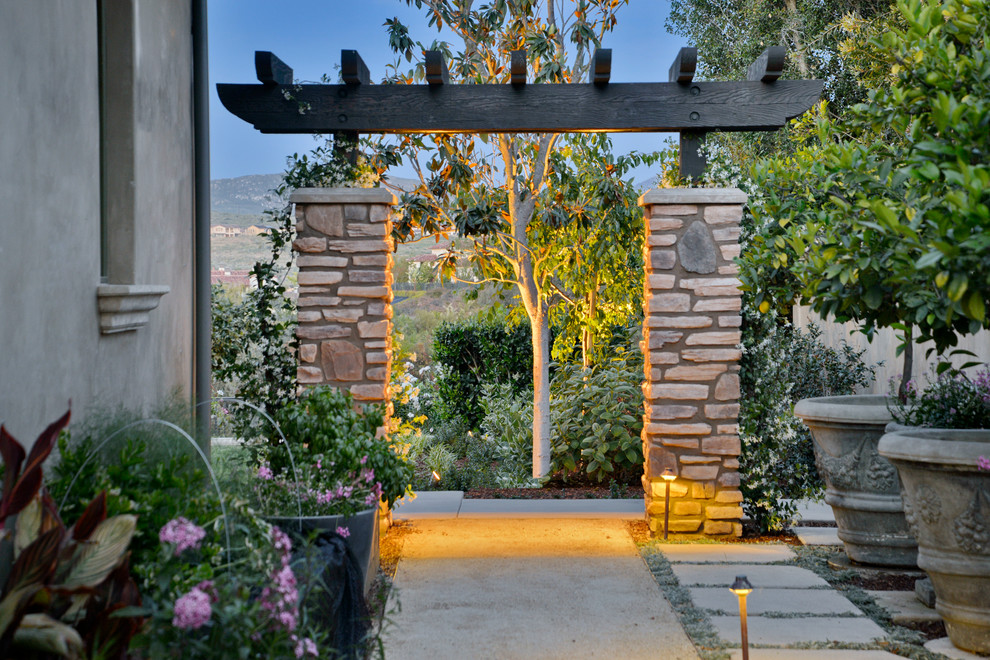 Modelo de patio mediterráneo de tamaño medio en patio lateral con jardín de macetas, adoquines de hormigón y pérgola