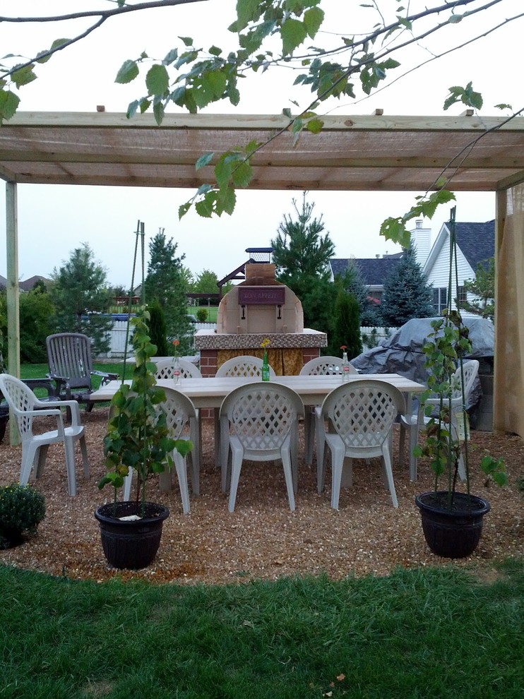 Idée de décoration pour une terrasse arrière tradition de taille moyenne avec une cuisine d'été et une pergola.