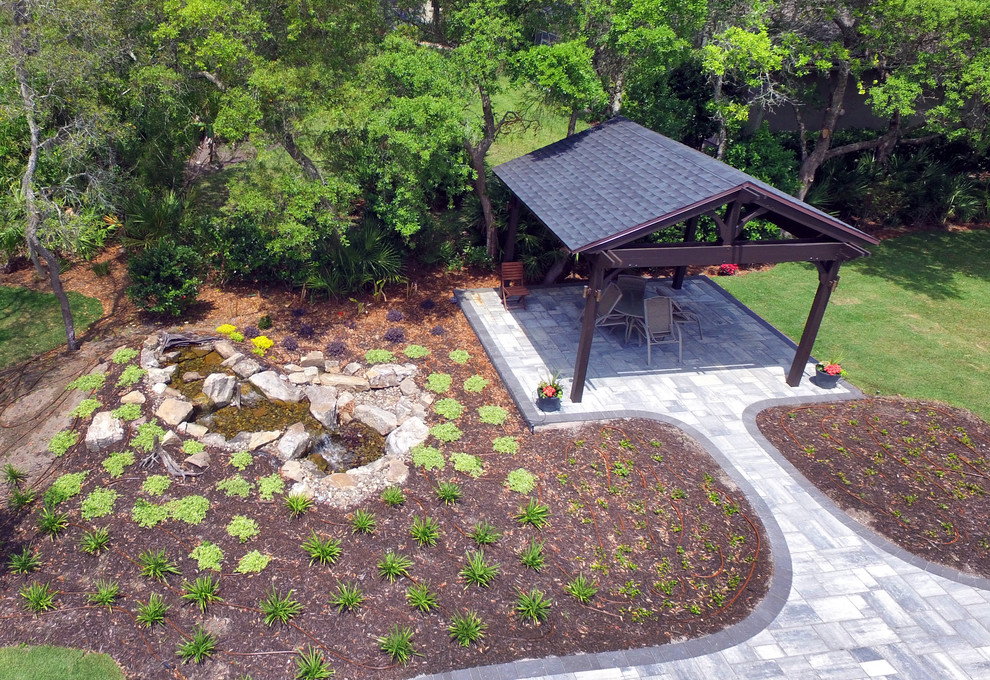 Modelo de patio tradicional extra grande en patio trasero con fuente, suelo de hormigón estampado y toldo