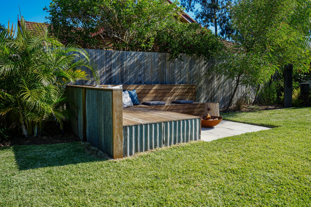На фото: двор в современном стиле с местом для костра без защиты от солнца