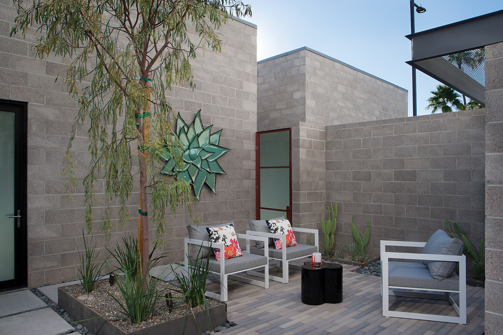 Photo of a small contemporary back patio in Phoenix with natural stone paving and no cover.