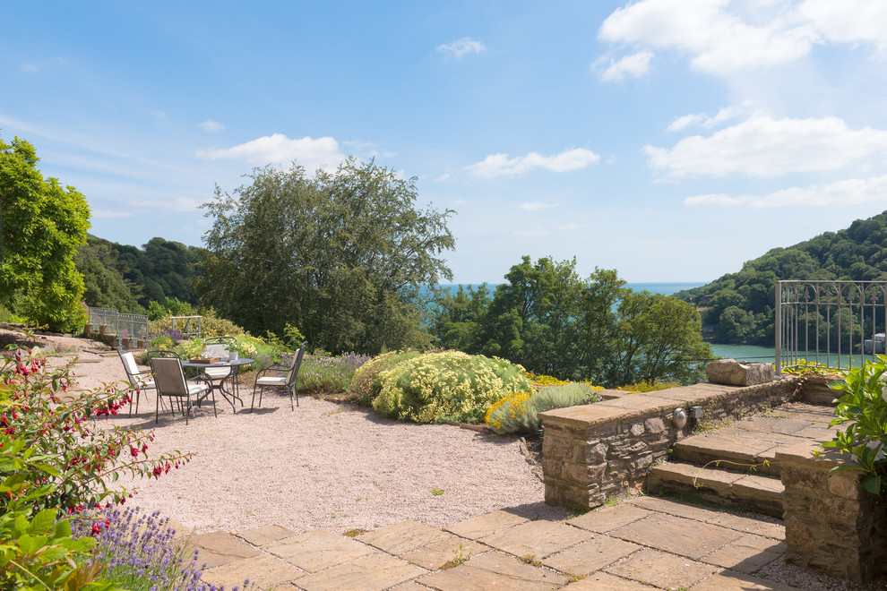 Design ideas for an expansive rural patio in Devon with a water feature and gravel.