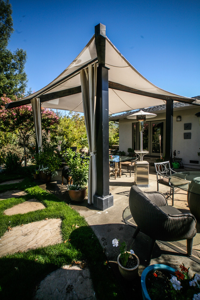 Inspiration for a large timeless backyard stone patio remodel in San Francisco with a fire pit and an awning