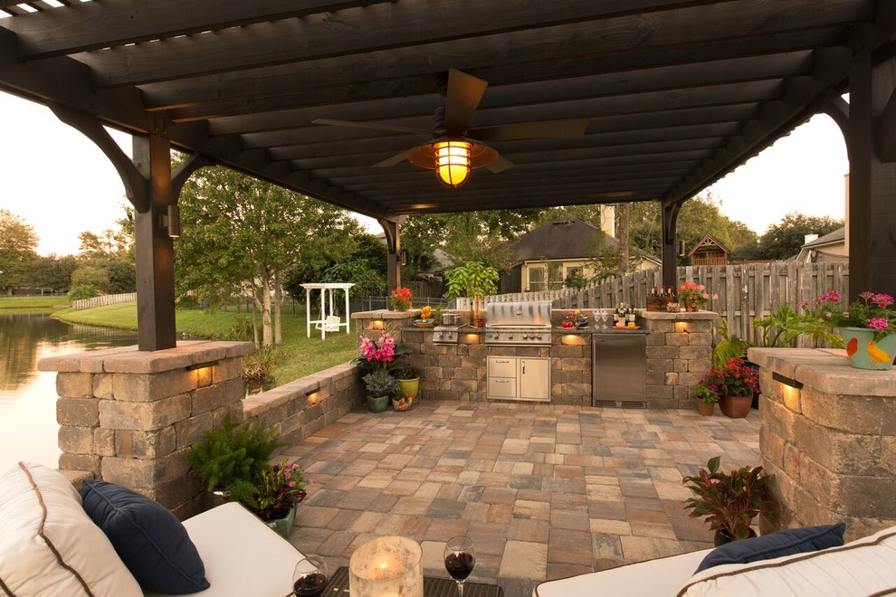 Esempio di un patio o portico classico dietro casa e di medie dimensioni con pavimentazioni in pietra naturale e una pergola