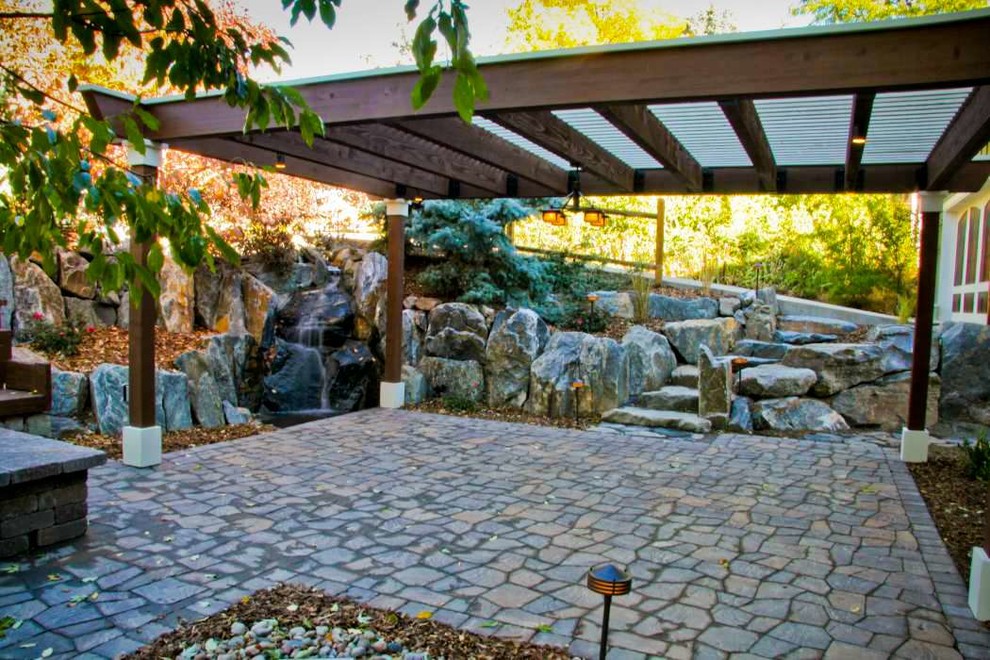 Immagine di un patio o portico american style di medie dimensioni con pavimentazioni in cemento e un gazebo o capanno