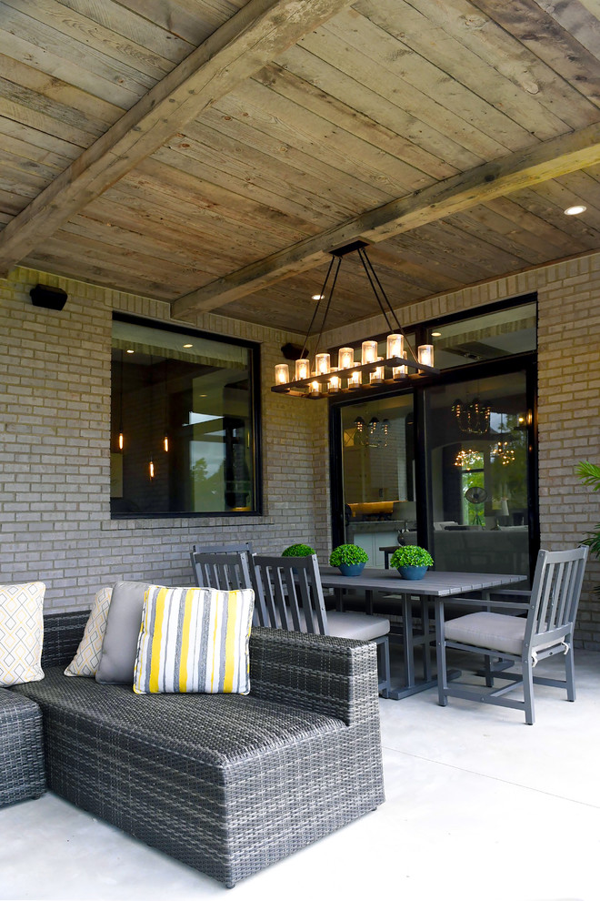 Cette image montre une terrasse arrière traditionnelle de taille moyenne avec une cuisine d'été, une dalle de béton et une extension de toiture.