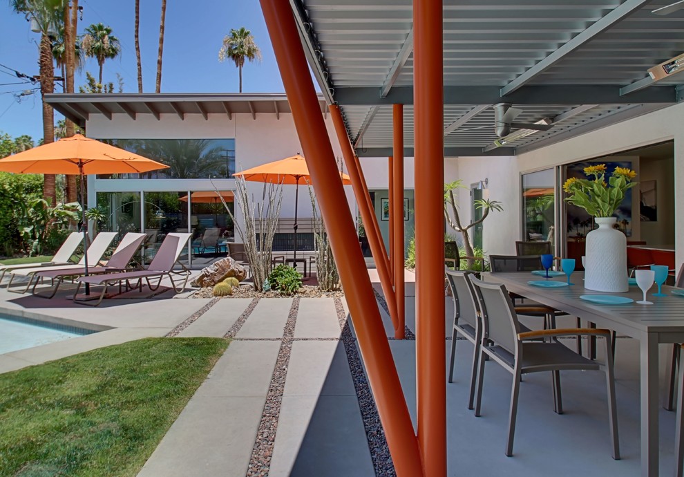 ロサンゼルスにある広いミッドセンチュリースタイルのおしゃれな裏庭のテラス (アウトドアキッチン、コンクリート敷き	、パーゴラ) の写真