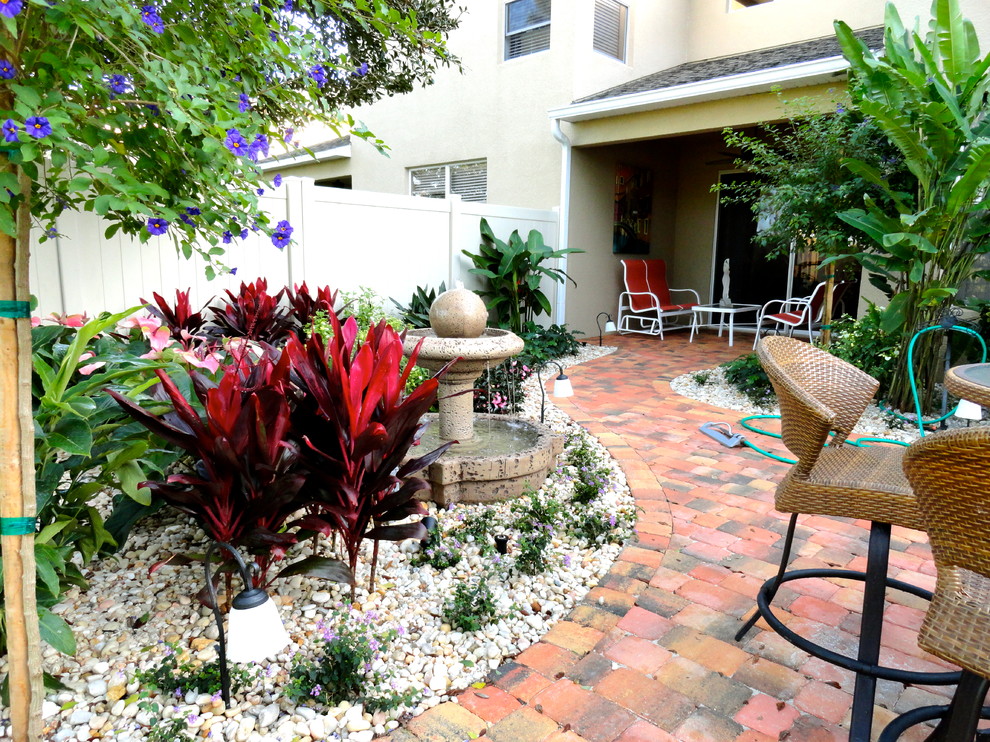 Mittelgroßer, Überdachter Klassischer Patio hinter dem Haus mit Wasserspiel und Pflastersteinen in Orlando