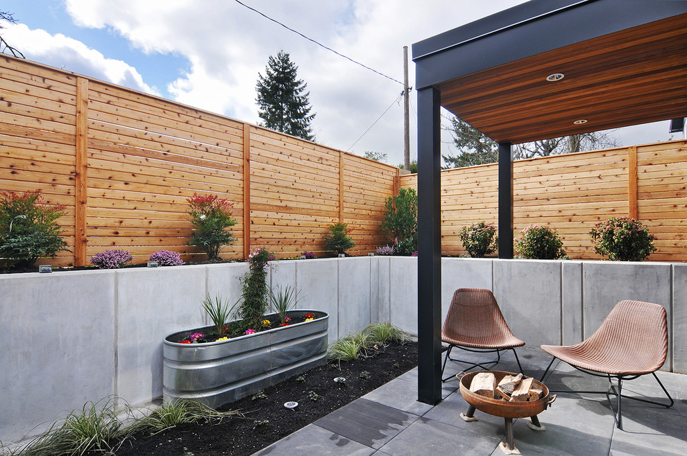 Diseño de patio actual pequeño en patio trasero y anexo de casas con jardín de macetas y adoquines de hormigón