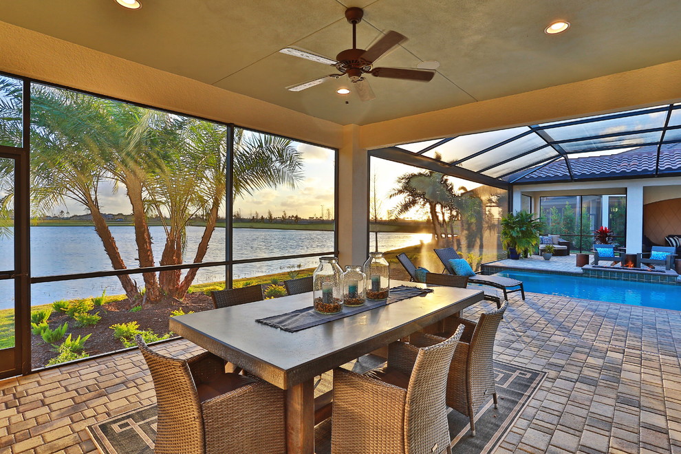 Cette photo montre une très grande terrasse arrière chic avec une cuisine d'été, des pavés en béton et une extension de toiture.
