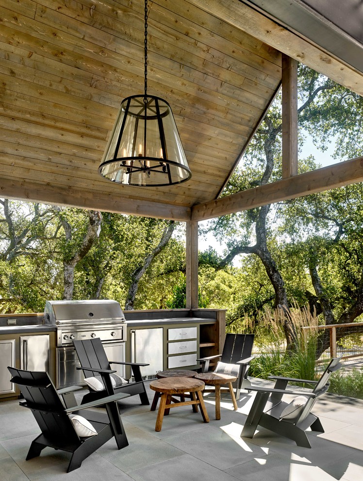 This is an example of a farmhouse patio in San Francisco with an outdoor kitchen and a roof extension.