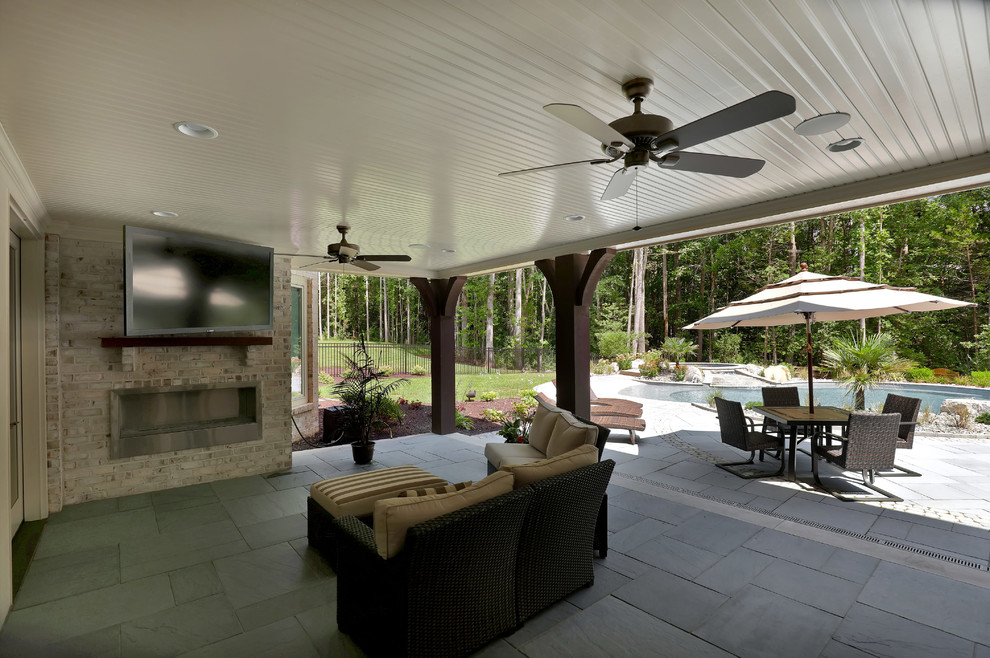 Inspiration for a huge transitional backyard stone patio remodel in Richmond with a fire pit and a roof extension