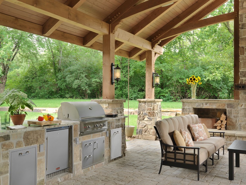 Traditional back patio in St Louis with an outdoor kitchen and an awning.