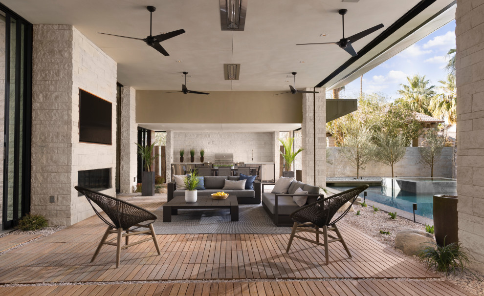 Large contemporary courtyard patio in Las Vegas with an outdoor kitchen, decking and a roof extension.