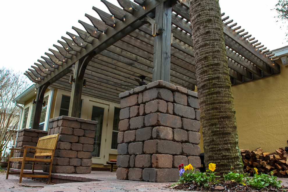 Diseño de patio tradicional de tamaño medio en patio trasero con cocina exterior, adoquines de ladrillo y pérgola