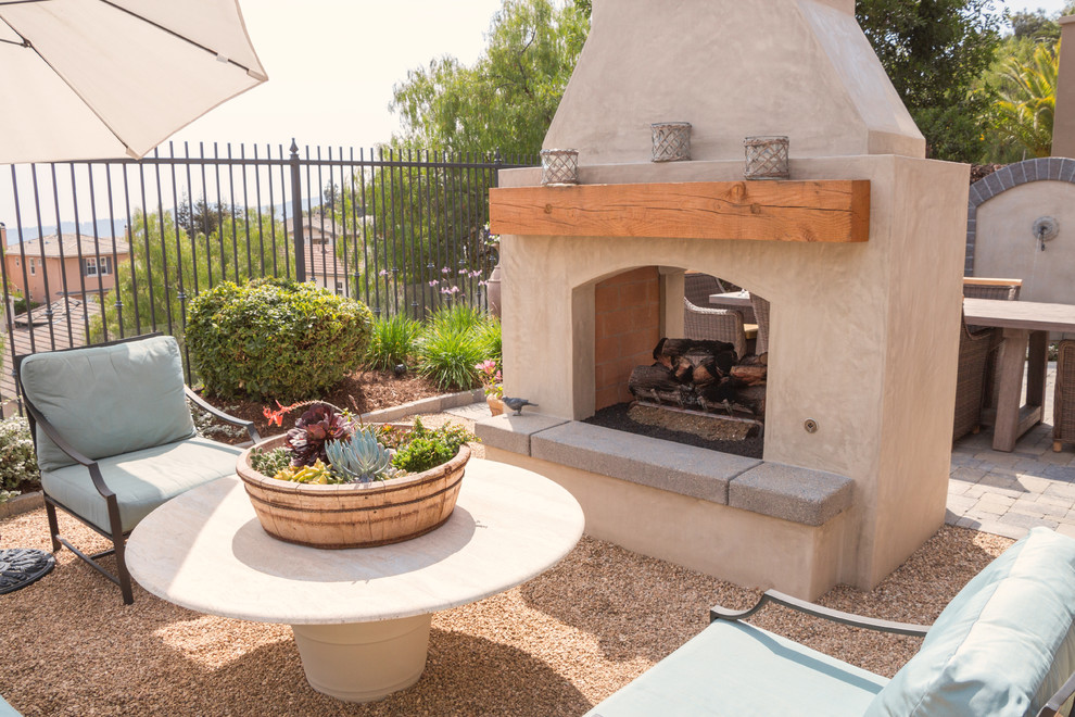 Mediterranean back patio in Los Angeles with a fire feature and decomposed granite.