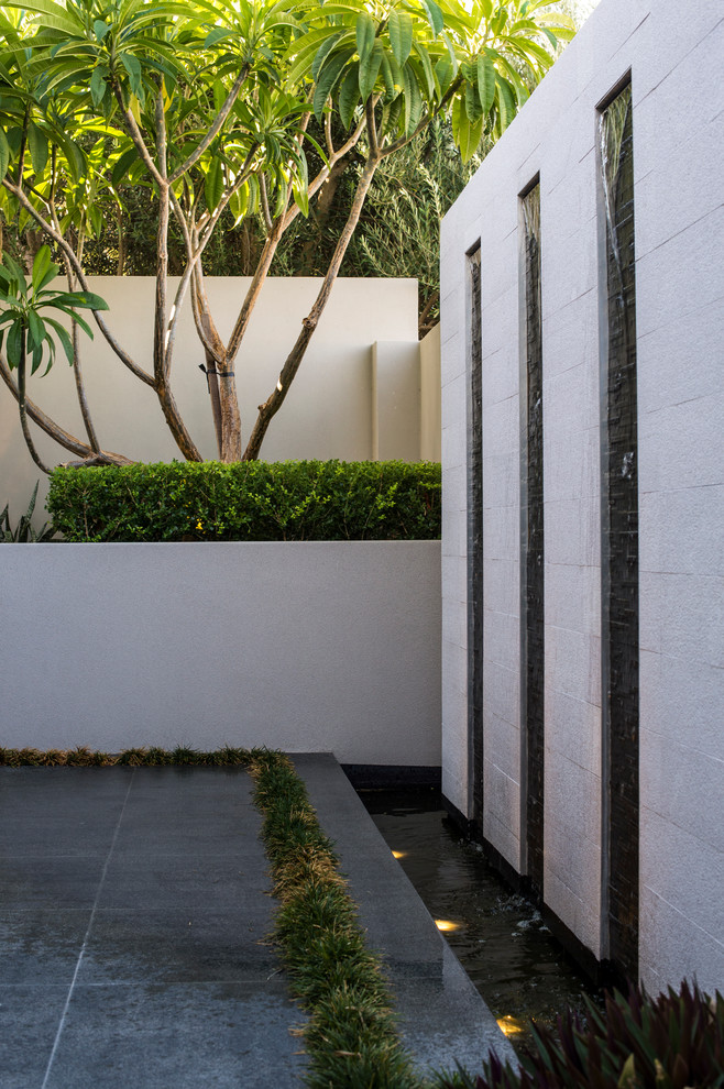 Ispirazione per un patio o portico moderno in cortile con pavimentazioni in pietra naturale
