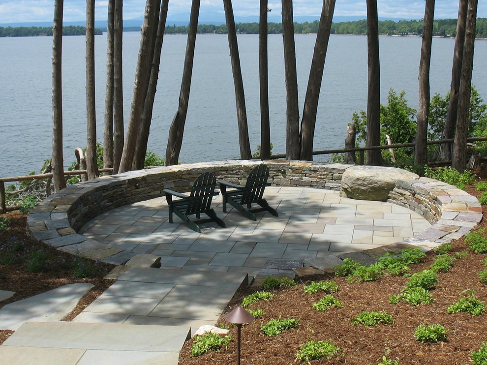 Example of a huge trendy backyard stone patio design in Burlington