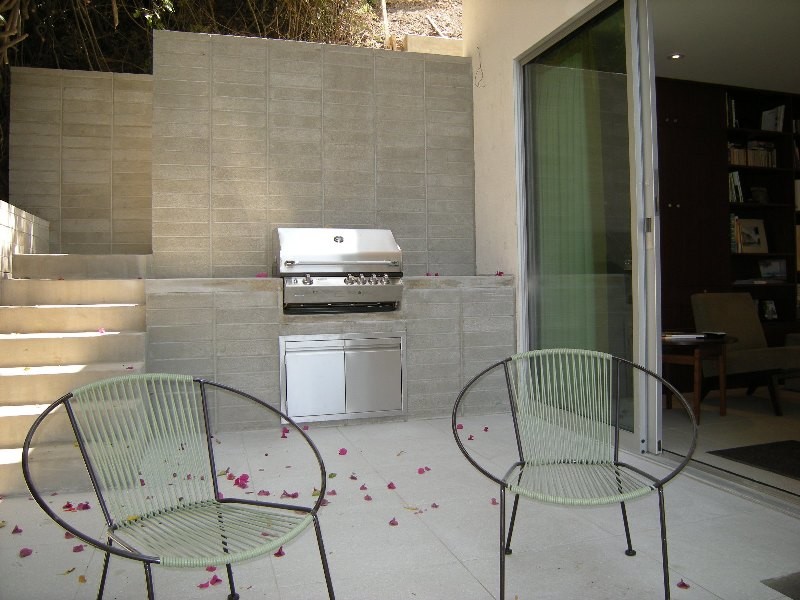 Patio kitchen - mid-sized mid-century modern side yard tile patio kitchen idea in Los Angeles with no cover