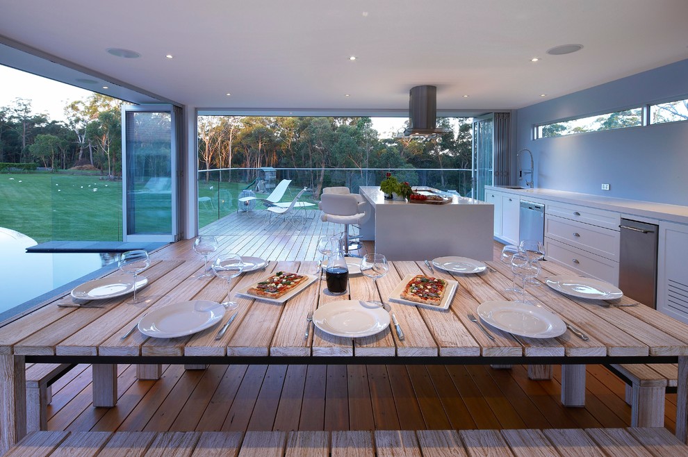 Idee per un patio o portico design con pedane e un tetto a sbalzo