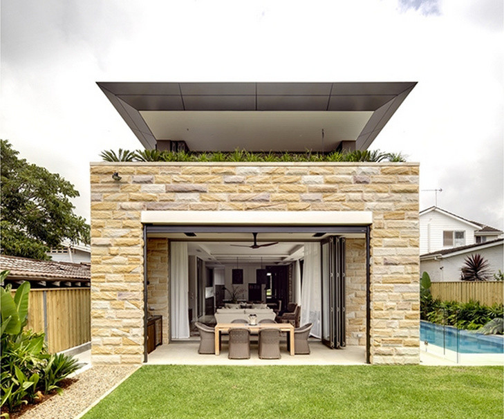 Foto di un ampio patio o portico stile marino dietro casa con pavimentazioni in pietra naturale e un tetto a sbalzo