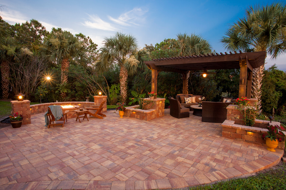 Imagen de patio clásico extra grande en patio trasero con brasero, adoquines de piedra natural y pérgola
