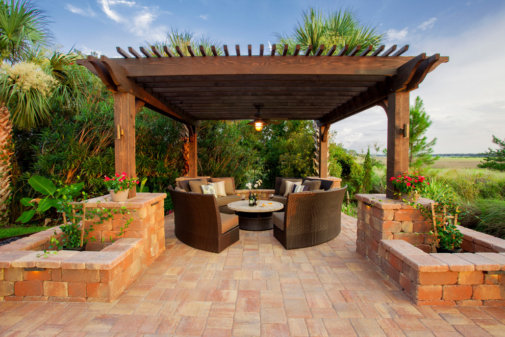 Photo of an expansive classic back patio in Jacksonville with a fire feature, natural stone paving and a pergola.