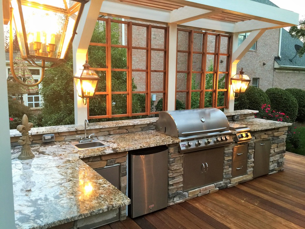 Large elegant backyard patio kitchen photo in Charlotte with decking and a pergola
