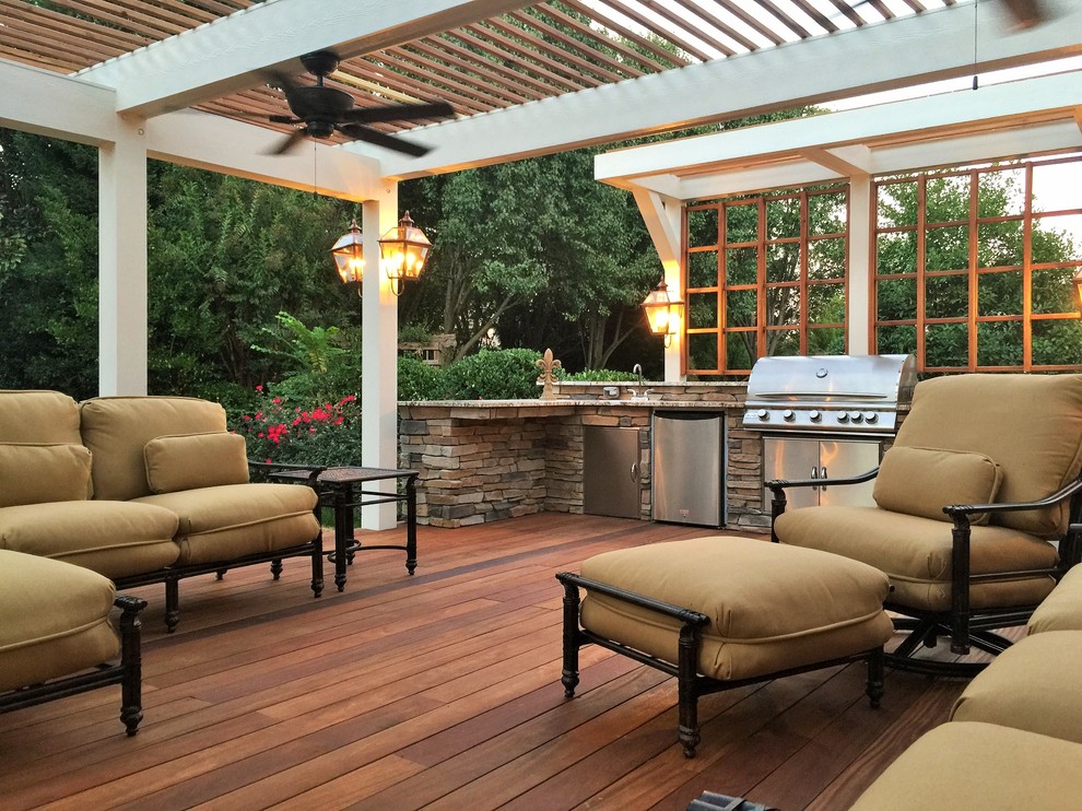 Example of a large classic backyard patio kitchen design in Charlotte with decking and a pergola