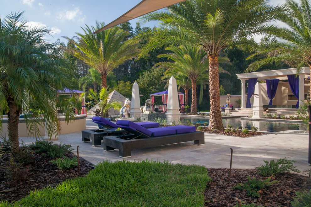 Photo of a large mediterranean back patio in Tampa with no cover and natural stone paving.