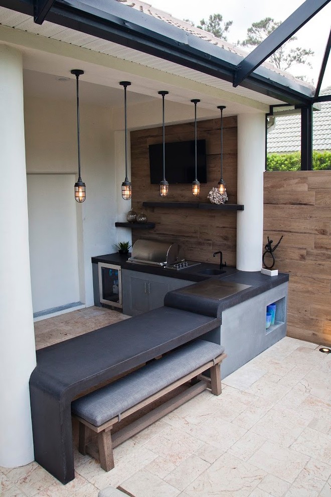 Foto di un grande patio o portico minimalista dietro casa con pavimentazioni in pietra naturale e un tetto a sbalzo