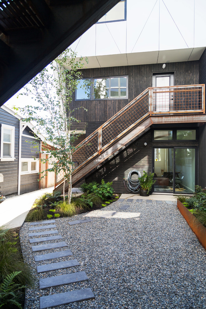 Ispirazione per un patio o portico minimal di medie dimensioni e in cortile con un giardino in vaso, pavimentazioni in cemento e un tetto a sbalzo