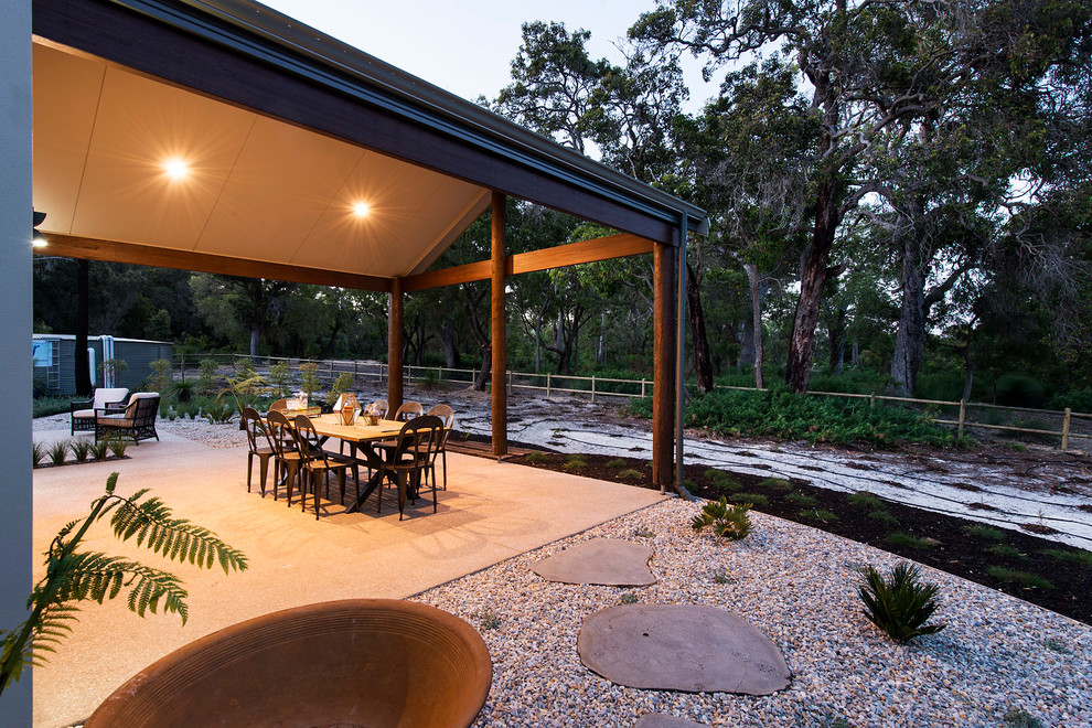Idee per un grande patio o portico minimal dietro casa con lastre di cemento e un tetto a sbalzo