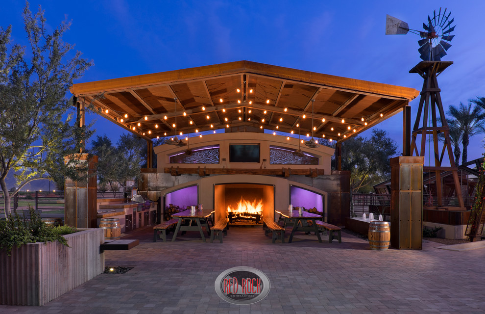 This is an example of an expansive country back patio in Phoenix with an outdoor kitchen, concrete paving and an awning.