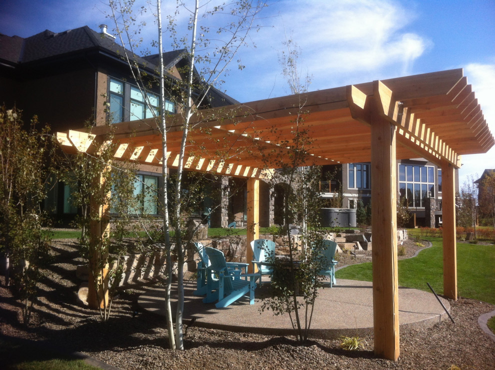 Inspiration for a large timeless courtyard stone patio remodel in Calgary with a fire pit and a pergola