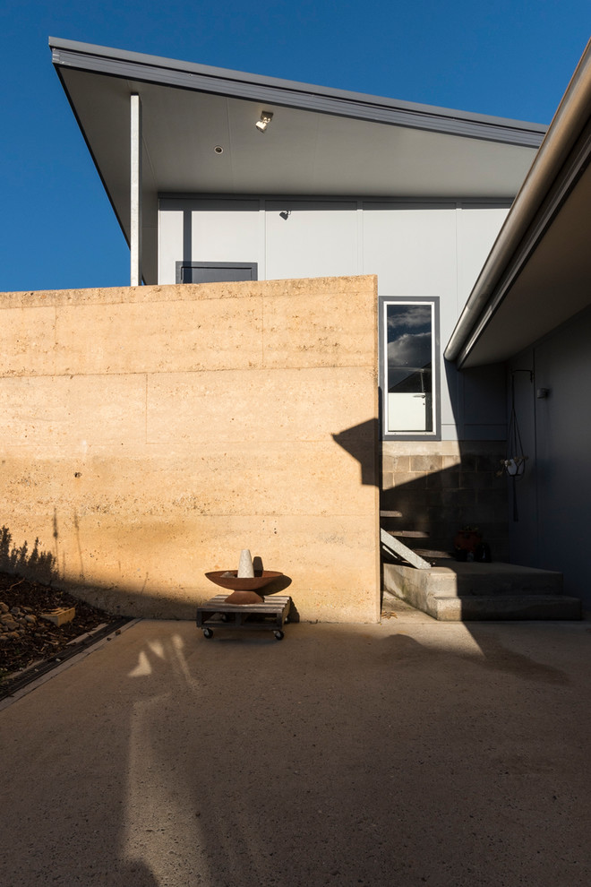 Mittelgroßer, Überdachter Moderner Patio im Innenhof mit Feuerstelle und Betonplatten in Sonstige