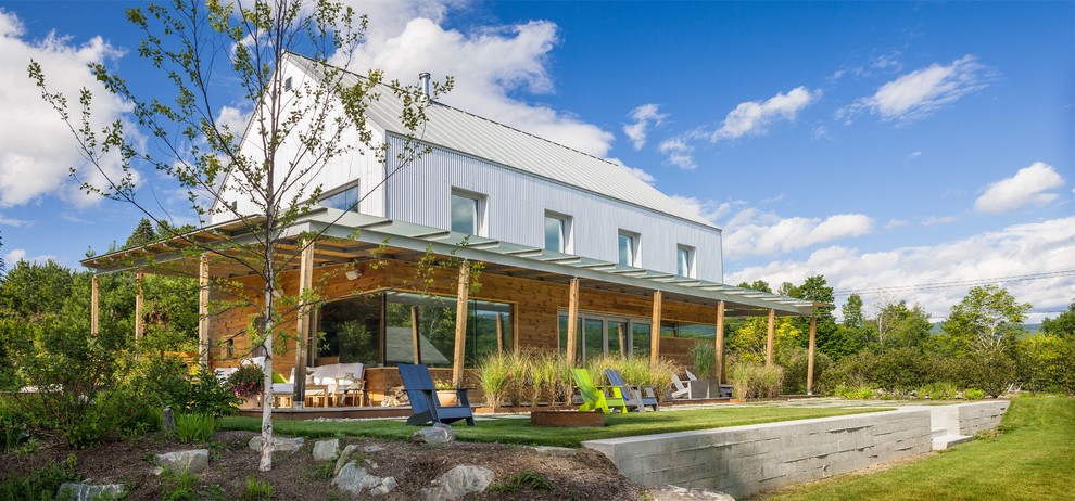 Cette image montre une terrasse arrière minimaliste avec une extension de toiture.